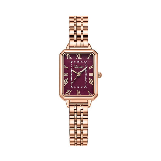 Rose gold watch with a maroon face on a white background
