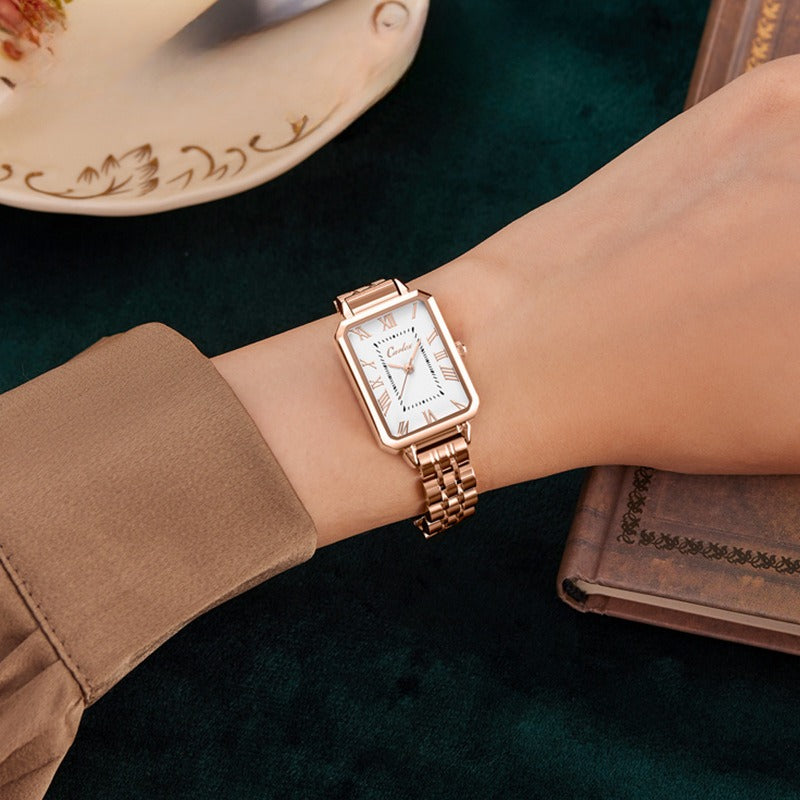 Rose gold tank watch with a white face on a white background